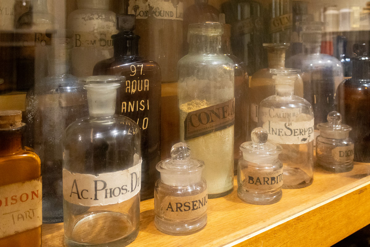 Empty glass medicine bottles arranged in a cabinet