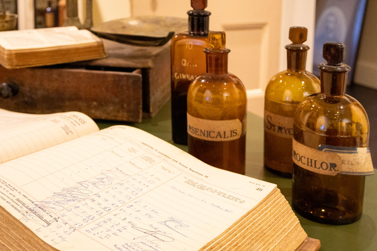 Hospital poisons registration book surrounded by empty glass bottles